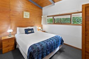 Un dormitorio con una cama grande y una ventana en Clarendon Chalets, en Mount Gambier