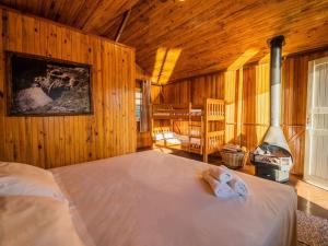 um quarto com uma cama e uma lareira num quarto em Costão do Cambará Pousada Fazenda em Cambará