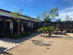 een gebouw met bomen en planten ervoor bij Estancita Elena in Valle de Guadalupe