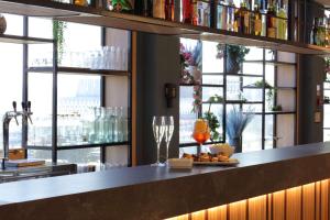 菲亚诺罗马诺Hampton by Hilton Rome North Fiano Romano的有玻璃杯和一盘食物的酒吧