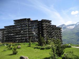 a large building on a hill with mountains in the background at Résidence Home Club - Studio pour 4 Personnes 71 in Tignes