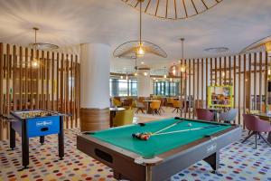Hampton By Hilton Sharma - NC1 في Khuraybah: غرفة بلياردو مع طاولة بلياردو وطاولات