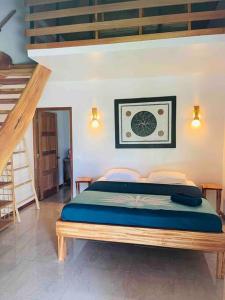 - une chambre avec un lit dans une pièce avec des escaliers dans l'établissement Bungalow Tiarii, avec accès direct à une plage privée, à Tevaitoa