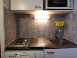 una cocina con fregadero y estufa horno superior en Résidence Fond Blanc - Studio pour 4 personnes à Arc 2000 proche des commerces et des pistes MAE-1788, en Arc 2000