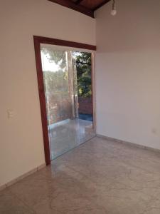 um quarto vazio com uma porta de vidro deslizante em Casa taipu de dentro em Maraú