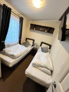 dwa łóżka w pokoju z oknem w obiekcie 163 Holiday Resort Unity Brean - Centrally Located Pet Stays Free - Passes Included No Workers sorry w mieście Brean