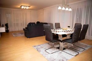 a dining room with a table and chairs and a couch at Deluxe Apartment in Kahl am Main