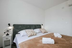 um quarto com uma cama grande com duas toalhas em Apartments with a parking space Trogir - 22616 em Trogir