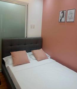 uma cama com duas almofadas num quarto em Apartment-Serviced & Condo Free pool in Quezon City by Mi'Casa em Manila