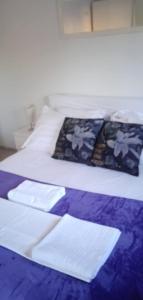 ein Bett mit einer blauen und weißen Decke und Kissen in der Unterkunft Family friendly house with a swimming pool Imotski, Zagora - 22623 in Imotski