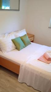 ein weißes Bett mit zwei Kissen darüber in der Unterkunft Family friendly house with a swimming pool Imotski, Zagora - 22623 in Imotski