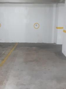 eine leere Parkgarage mit einer Uhr an der Wand in der Unterkunft Habitación individual Business in Quito