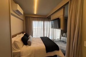 um quarto de hotel com uma cama e uma televisão em Studio C9 de alto padrão em Marília