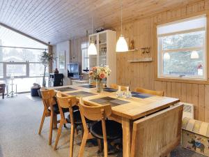 uma sala de jantar com uma mesa de madeira e cadeiras em Holiday home Fjerritslev XIX em Fjerritslev