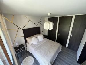 een slaapkamer met een bed met een wit dekbed bij Nuevo Depto en ubicación privilegiada in Santiago