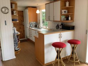 eine Küche mit zwei roten Stühlen an der Theke in der Unterkunft Holiday home Struer XXX in Struer