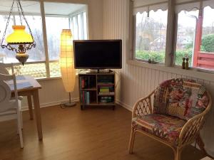 ein Wohnzimmer mit einem TV und einem Stuhl in der Unterkunft Holiday home Struer XXX in Struer