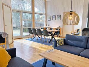 a living room with a couch and a table and chairs at Holiday home Hasle CIX in Hasle