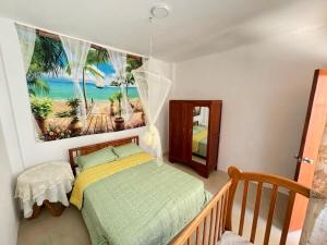 a bedroom with a bed and a picture of the beach at Hospedaje Don Lalo in Tortuga