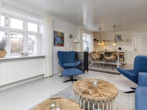 LæsøにあるHoliday home Læsø XVIIのリビングルーム(青い椅子、テーブル付)