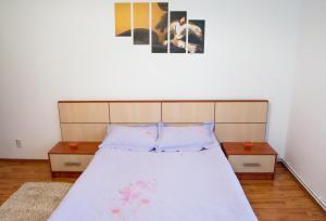 a bedroom with a large bed with two tables at Apartament Central Onix in Braşov