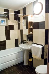a bathroom with a sink and a tub and a toilet at Apartament Central Onix in Braşov