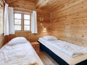 a bedroom with two beds in a wooden cabin at Holiday home Læsø XII in Læsø