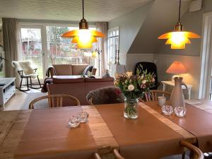 een woonkamer met een houten tafel met bloemen erop bij Holiday home Struer XXIX in Struer