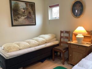 ein Schlafzimmer mit einer Bank mit einer Lampe und einem Stuhl in der Unterkunft Holiday home Struer XXIX in Struer