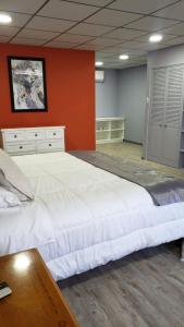 ein großes Bett in einem Zimmer mit einer roten Wand in der Unterkunft Hotel Boutique Grand Cru in Santa Cruz