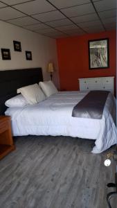 a bedroom with a large white bed with orange walls at Hotel Boutique Grand Cru in Santa Cruz