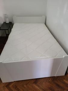 uma cama branca num quarto em Zelena Oaza em Jagodina