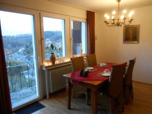 a dining room with a red table and chairs and windows at Holiday apartment dream view 2 in Monschau +14 photos