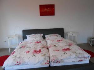 a bed with white sheets and pink flowers on it at Holiday apartment dream view 2 in Monschau