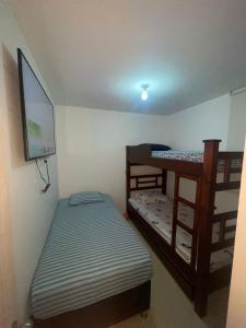 Una habitación con dos literas y un televisor de pantalla plana. en HERMOSO APARTAMENTO AMOBLADO PARA DESCANSO, en La Tebaida