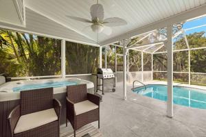 a patio with a tub and a swimming pool at Secluded Backyard Home with Hot Tub & Pool - 3BR & 2B in Fort Myers