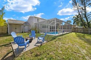 a yard with chairs and a pool in a greenhouse at Secluded Backyard Home with Hot Tub & Pool - 3BR & 2B in Fort Myers