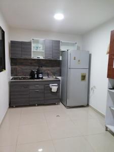 a kitchen with a refrigerator and a sink at Casa completa al frente del centro comercial alamedas in Montería