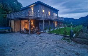 ein großes Holzhaus mit einem Picknicktisch davor in der Unterkunft 4 Bedroom Gorgeous Home In Lindesnes in Kvåfjord