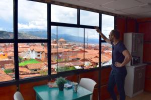 Un uomo in piedi davanti a una finestra che guarda fuori di The Chusay Rooftop a Cuzco