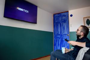 a man sitting in a chair holding a cell phone at The Chusay Rooftop in Cusco