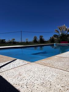 a swimming pool with a blue sky in the background at Pasos de la Naturaleza in San Andrés de Giles +30 photos