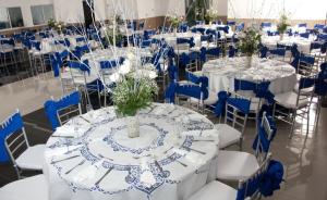 a room with tables and chairs with blue and white at Hotel Fundacooedumag Rodadero in Santa Marta