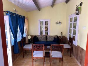 a living room with a blue couch and a table at Kanjira house in Ooty