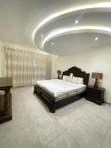 ein Schlafzimmer mit einem Bett und einer großen Decke in der Unterkunft فيلا ساحل القمر(البردايس) ارخصــ الاسعــار in Durrat Al-Arus