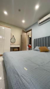 ein Schlafzimmer mit einem großen Bett mit einer blauen Decke in der Unterkunft LAD homestay & Apartment - Hoàng Huy Đổng Quốc Bình in Haiphong