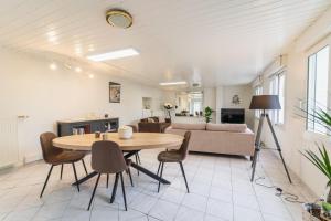 un salon avec une table, des chaises et un canapé dans l'établissement Le Gué Sourdeau: 150m² 5 min from Futuroscope, à Chasseneuil-du-Poitou