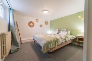 um quarto com uma cama com paredes verdes em Le Gué Sourdeau: 150m² 5 min from Futuroscope em Chasseneuil-du-Poitou