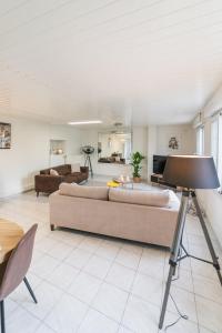 un salon avec un canapé et une table dans l'établissement Le Gué Sourdeau: 150m² 5 min from Futuroscope, à Chasseneuil-du-Poitou