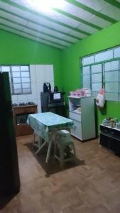 - une cuisine avec une table et un mur vert dans l'établissement Casa da Vila Encantada, à São Thomé das Letras